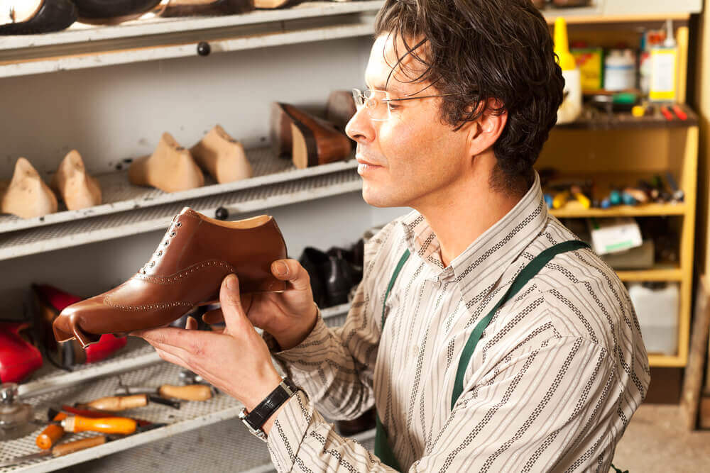 Cobbler working on a leather shoe in a workshop