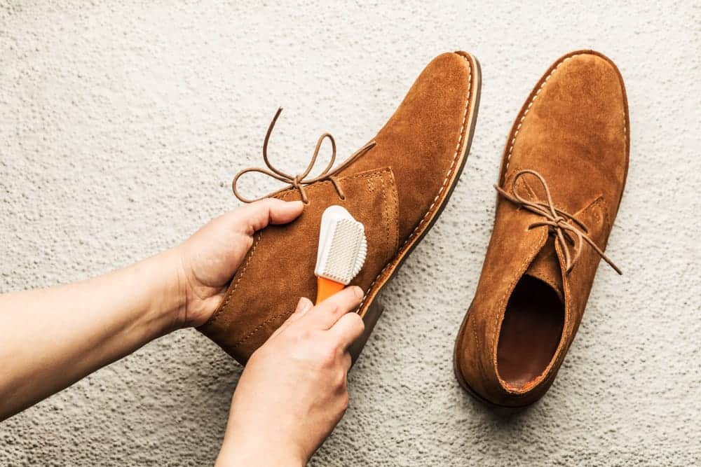 A person carefully cleaning white sneakers
